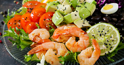 Grilled shrimps and fresh vegetable salad - avocado, tomato, black beans, red cabbage and paprika